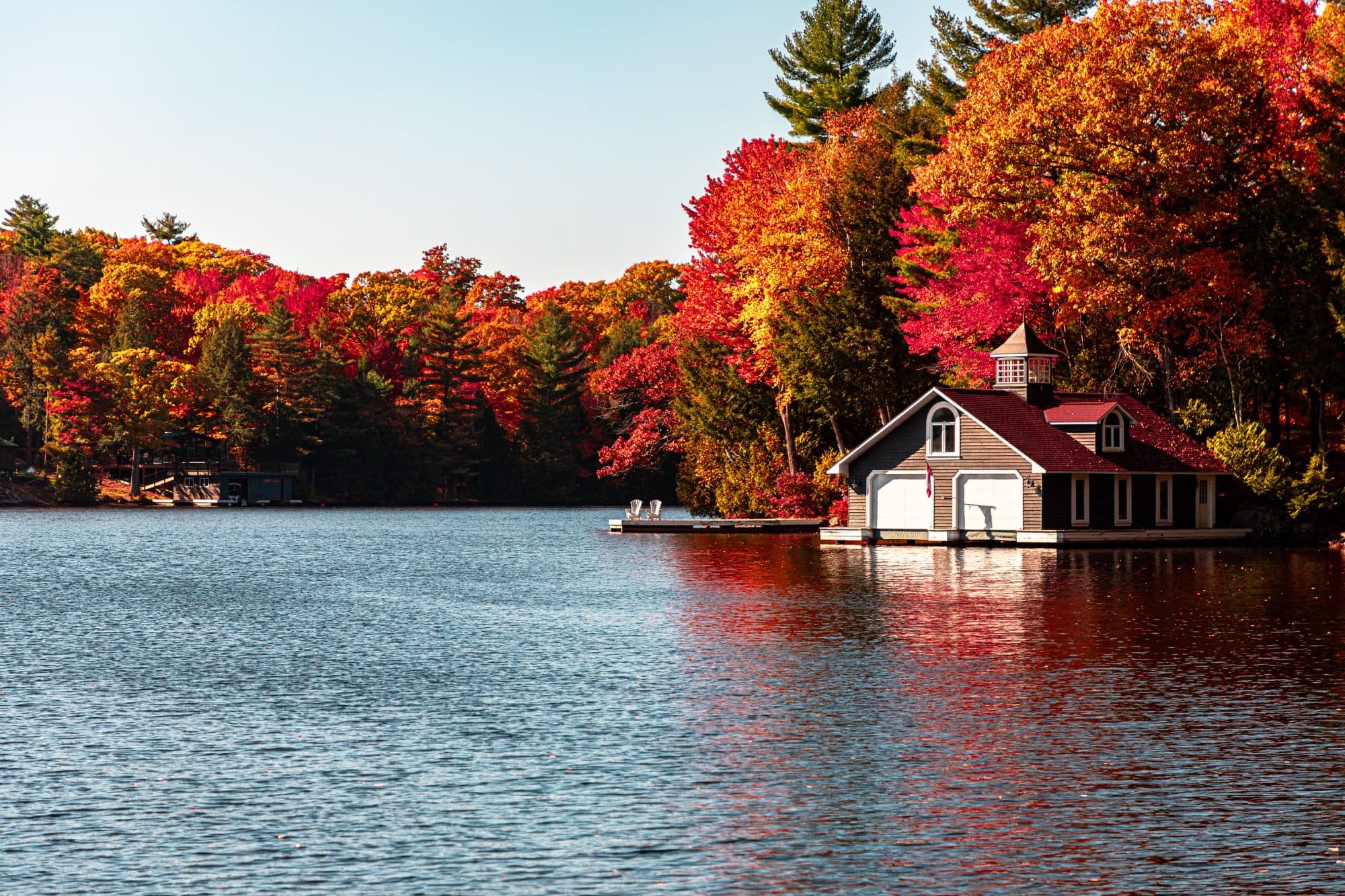 Boathouse on a lake surrounded by autumn trees